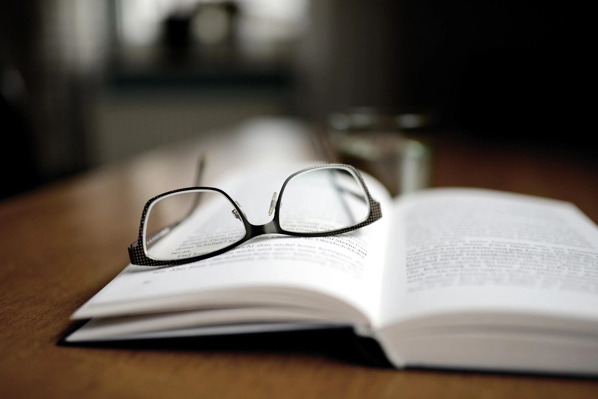 Open book with reading glasses placed on top, symbolizing learning and understanding of tax and accounting concepts.