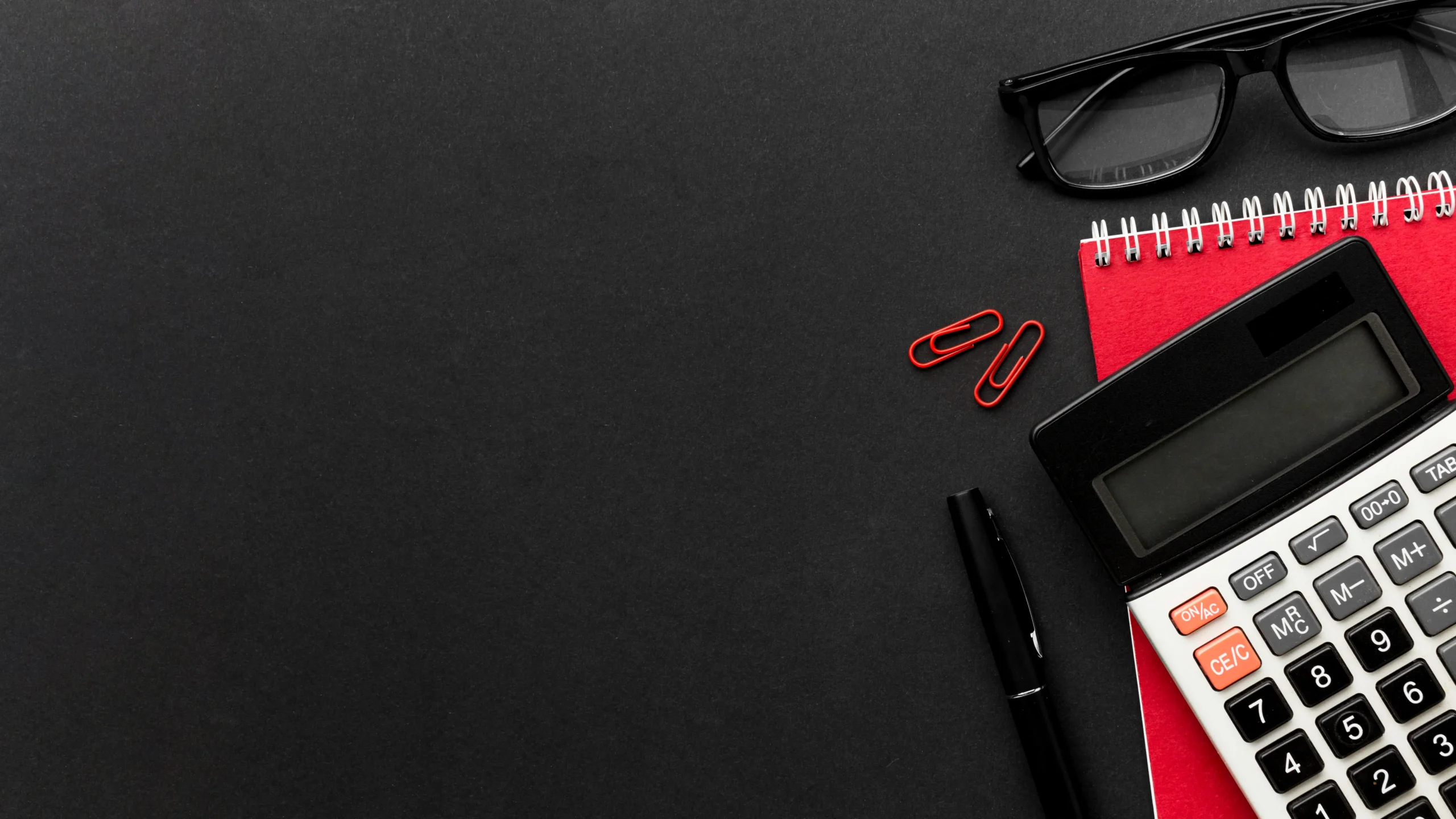 Calculator, glasses, and notebook on a desk illustrating accounting services