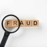 Magnifying glass highlighting the word "fraud" to represent financial investigation and risk detection through bookkeeping services.