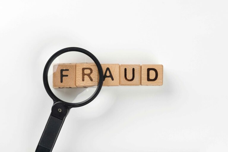 Magnifying glass highlighting the word "fraud" to represent financial investigation and risk detection through bookkeeping services.