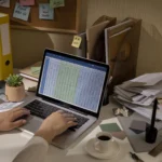 Messy table with invoices and financials reflecting the need for bookkeeping services