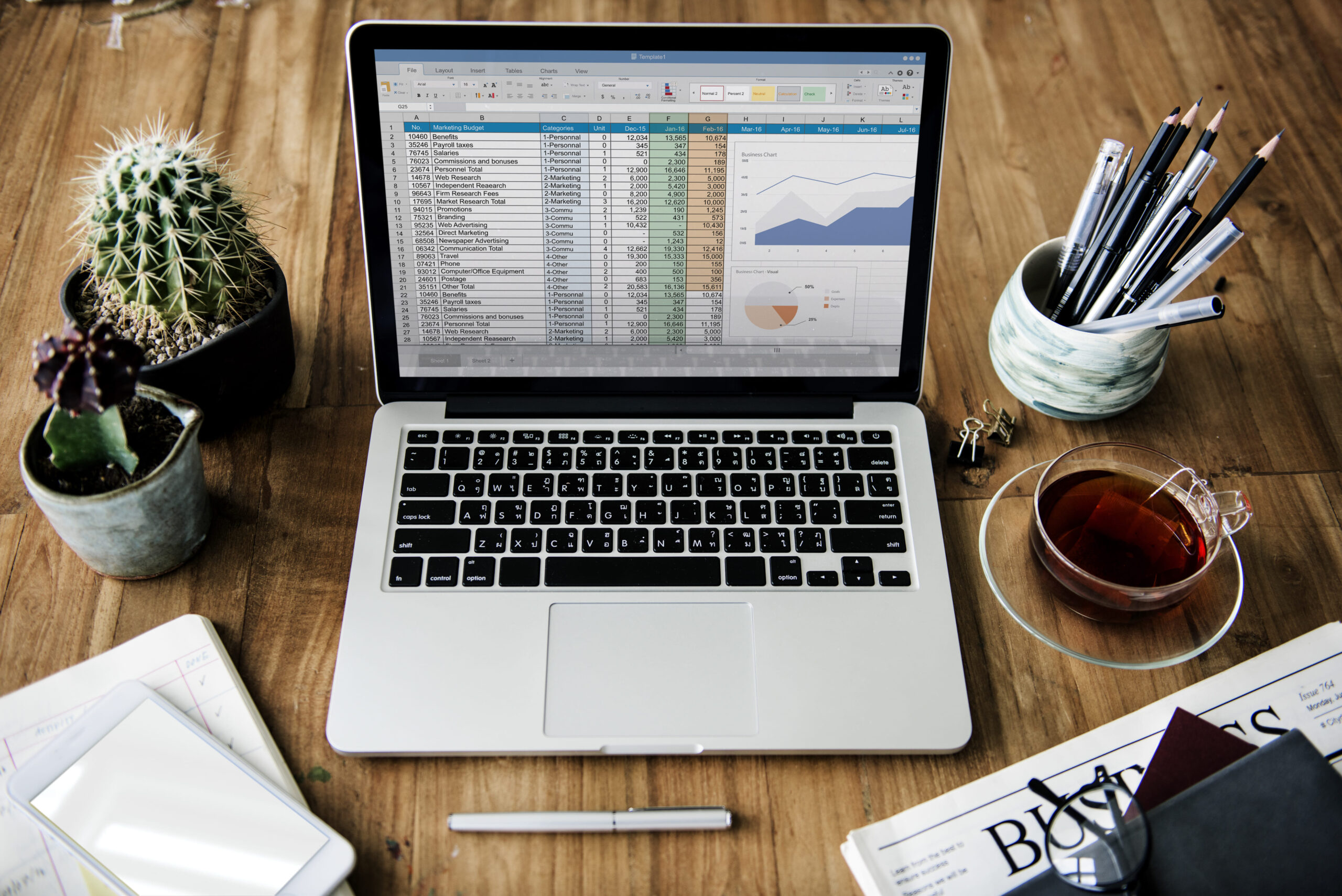 QuickBooks online advanced dashboard displayed on a laptop with coffee and notebook nearby